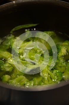 Fresh green broccoli cooked boiled in a pan, boiling water