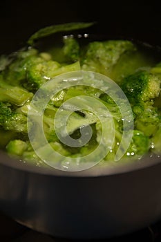 Fresh green broccoli cooked boiled in a pan, boiling water