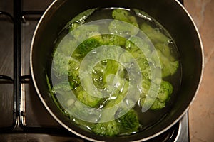 Fresh green broccoli cooked boiled in a pan, boiling water