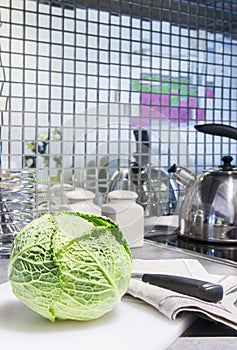 Fresh green cabbage with knife on chopping board