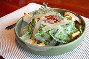 fresh green caesar salad with bacon and cheese on top
