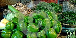 fresh green capsicum isolated on wooden basket at vegetable store