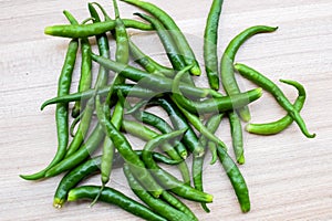 Fresh Green chili pepper on plain wooden table, green essential vegetables for all essential foods, view of unpeeled vegetables