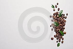 Fresh green coffee leaves and beans on light background, flat lay.