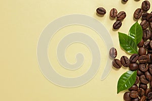 Fresh green coffee leaves and beans on light yellow background, flat lay