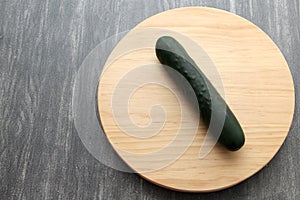 Fresh, green cucumbers on a chopping board with knife are prepared for a nutritious salad or juice on a kitchen table