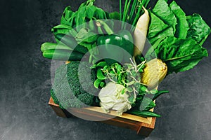 Fresh green fruit and green vegetables mixed in wooden box at market , top view various for healthy food vegan cook / Healthy food