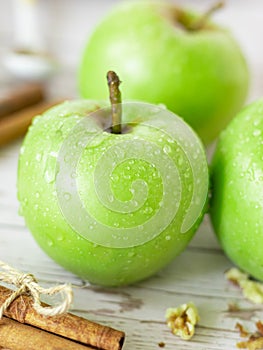 Fresh green Granny Smith apples with water drops on a wooden table