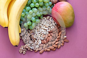 Fresh green grape banana and mango with nuts view from above, healthy lifestyle concept