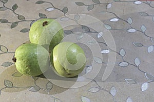 fresh green guavas on patterned surface