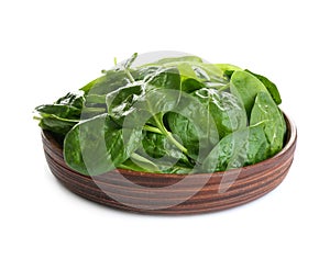 Fresh green healthy baby spinach leaves in wooden plate isolated on