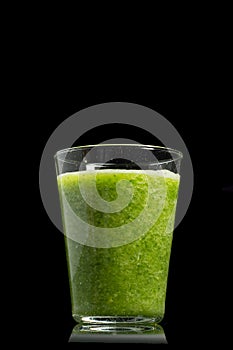 Fresh green healthy cucumber smoothie isolated on black background