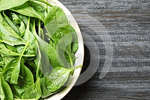 Fresh green healthy spinach on dark wooden table. Space for text