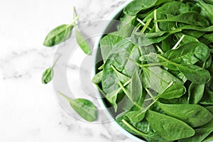 Fresh green healthy spinach on white marble table, top view.