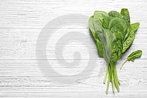 Fresh green healthy spinach on white wooden table. Space for text