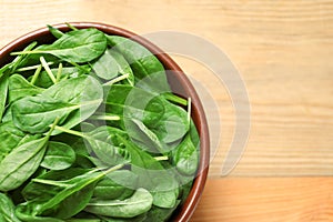 Fresh green healthy spinach on wooden table, top view.