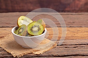 fresh green kiwis slice in the white bowl on the brown sack