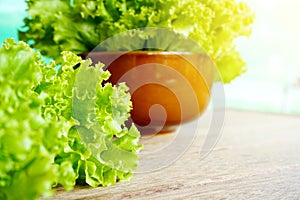 Fresh green lettuce salad selective focus on wooden table