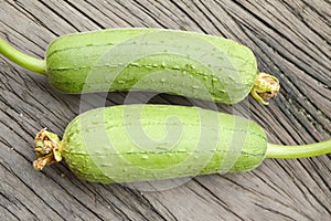 Fresh green Luffa cylindrica fruit on wooden table
