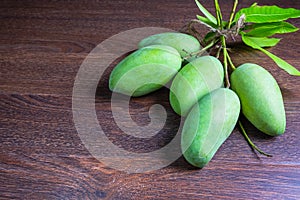 Fresh green mango fruit on a wooden table.