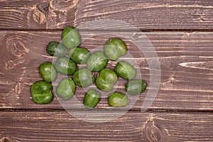 Fresh green mini baby kiwi fruit on brown wood