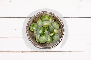 Fresh green mini baby kiwi fruit on grey wood