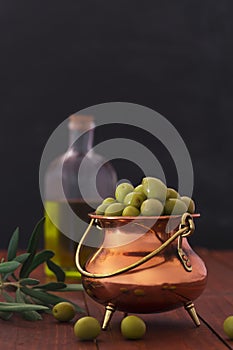 Fresh green olives on the wooden background. Vertical orientation