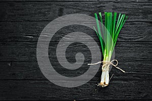 Fresh green onion on a wooden background.