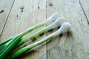 fresh green of onions on a wooden background, close up