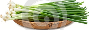 Fresh green onions in wooden bowl on white background, enhanced by natural lighting, vibrant colors