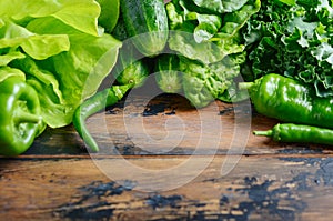 Fresh green organic vegetables on old wooden table.