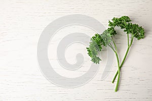 Fresh green parsley on white wooden table. Space for text