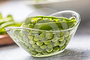 Fresh green pea seeds in bowl on kitchen table