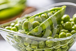 Fresh green pea seeds in bowl on kitchen table