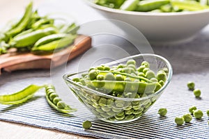 Fresh green pea seeds in bowl on kitchen table