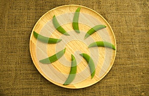 Fresh green peas on wooden dishware