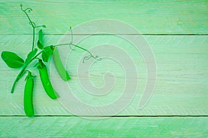 Fresh green pease from the garden on a wooden background