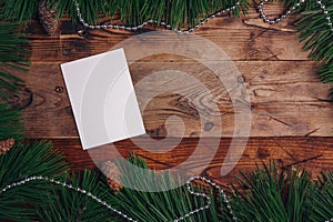 Fresh green pine branches and fir cones on wooden background, top view, copy space