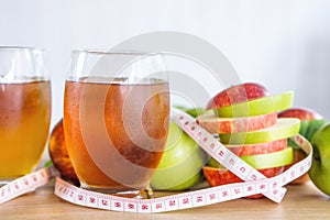 Fresh green and red apple slice and juice glasses with measuring tape