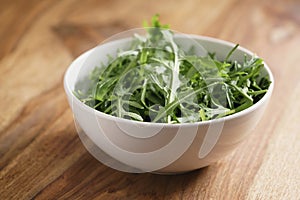 Fresh green rocket salad arugula leaves in white bowl