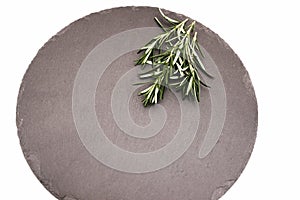 Fresh green rosemary twigs on a black stone plate