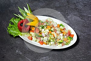 Fresh green salad with cucumber, tomato, onion, carrot served in dish isolated on grey background top view of indian and