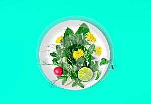 Fresh green salad with dandelions and edible flowers on a plate