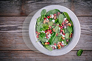 Fresh green salad with spinach, walnuts, goat cheese and pomegranate