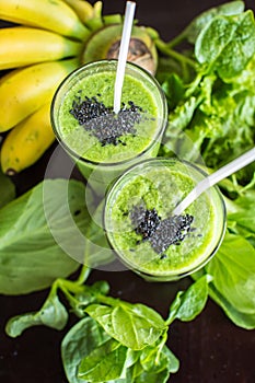 Fresh green smoothie with banana and spinach with heart of sesame seeds. Love for a healthy raw food concept.