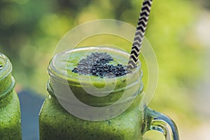 Fresh green smoothie with banana and spinach with heart of sesame seeds. Love for a healthy raw food concept