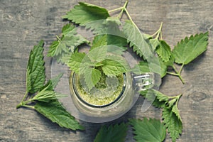 Fresh green smoothie with wild nettle and other herbs in mason jar.