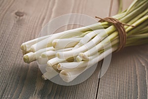 Fresh green spring onion tied with twine on old table