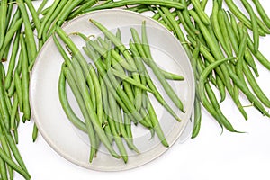 Fresh green string beans on a plate isolated on a white background