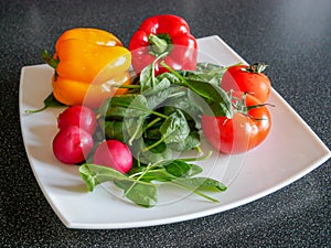 Fresh green vegetable salad with radish, tomatoes, color peppers